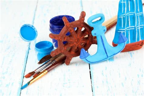 Premium Photo Hand Made Ceramic Toys And Color Paints On Wooden Table