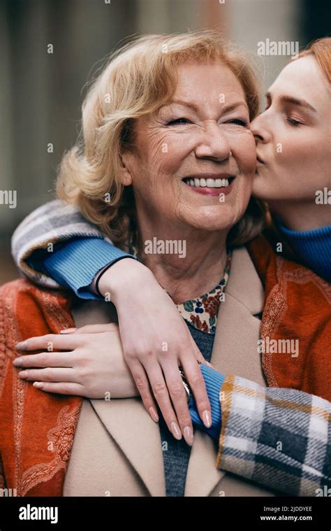 A Happy Grandmother And Granddaughter Hugging And Kissing Outside Stock