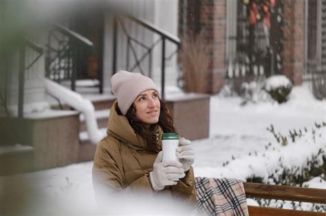 Premium Photo Cheerfully Brunette Woman Drinking From Flask Outdoors In The City In Winter