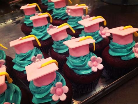 Graduation Cupcakes With Blue Frosting And Pink Decorations