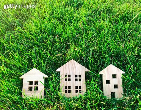 Miniature Wooden Houses On Green Grass Real Estate Concept Modern Housing Eco Friendly And