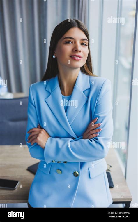 Portrait Of A Pretty Brunette In A Blue Jacket In The Office Near The