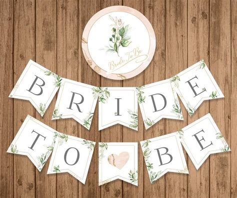 The Bride To Be Banner Is Hanging On A Wooden Wall With Greenery And Hearts