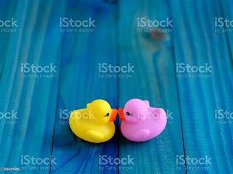 Two Rubber Ducks Purple And Yellow Kissing Together Scene Set On A