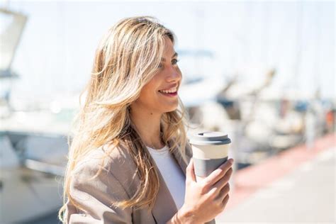 Jeune Jolie Femme Uruguayenne Blonde à L extérieur Tenant Un Café à Emporter Avec Une Expression
