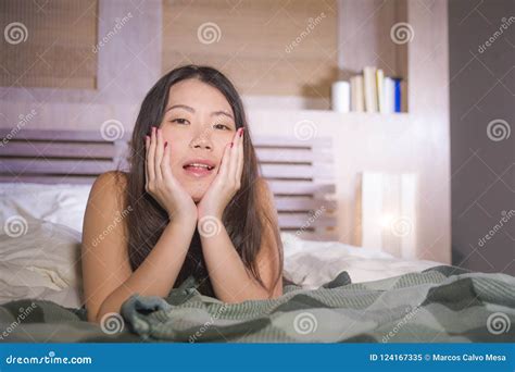 Lifestyle Portrait Of Young Beautiful And Happy Asian Chinese Woman Lying In Bed At Home Bedroom