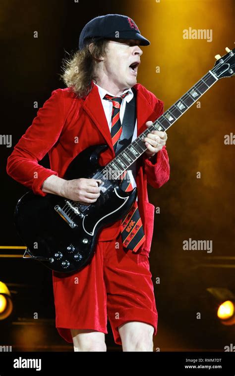 Guitarist Angus Young is shown performing on stage during a live concert appearance with Ac Dc ...