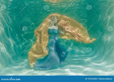 Hot Chubby Curvy Woman Posing Under Water In Beautiful Clothes Alone In The Deep Stock Photo