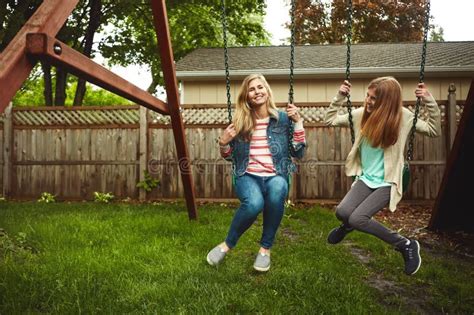 Having The Best Time In Our Own Backyard A Mother And Her Daughter Playing On A Swing In Their