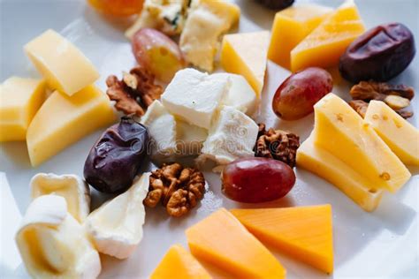 Cheese Platter With Nuts Grapes And Dates Delicious Snacks With Wine