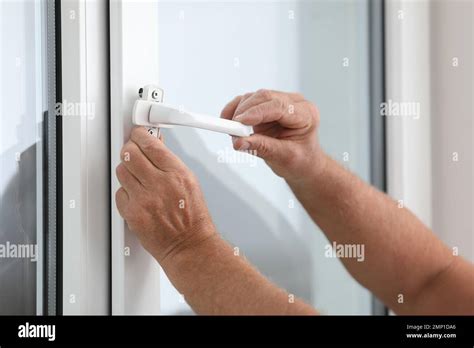 Mature Construction Worker Repairing Plastic Window Indoors Stock Photo