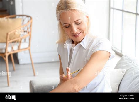 Mature Diabetic Woman Giving Herself Insulin Injection At Home Stock