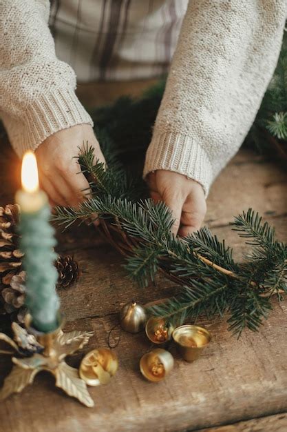 Guirlanda rústica de natal mãos femininas segurando ramos de abeto e