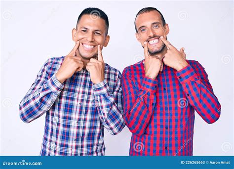 Joven Pareja Gay De Dos Hombres Con Ropa Informal Sonriendo Con Los Dedos De La Boca Abierta