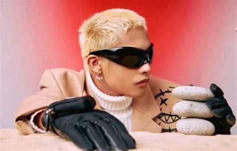 A Woman With Sunglasses And Gloves On Sitting At A Table