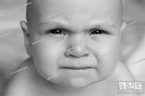 Baby Lies Naked On Her Stomach Looking At Camera Facial Expressions Portrait Stock Photo