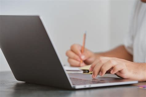 Premium Photo | A person writing on a laptop with a pencil.