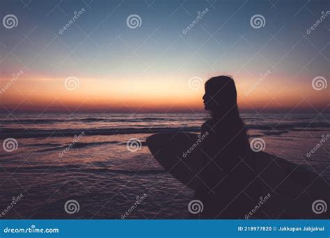 Silhouette Of Beautiful Surfer Female With Surfboard On The Sandy Beach