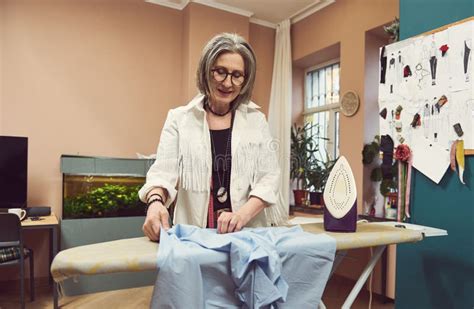Mature Years Old European Woman Fashion Designer Tailor Ironing Blue