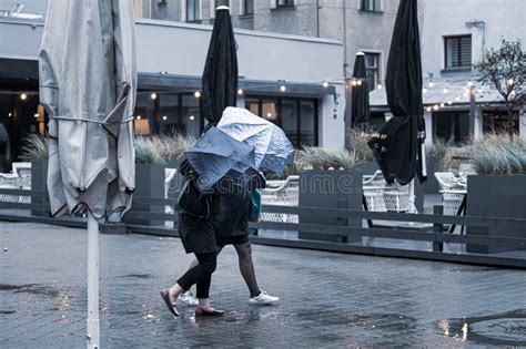 Girls Take Shelter With Umbrellas From Light Rain And Strong Wind