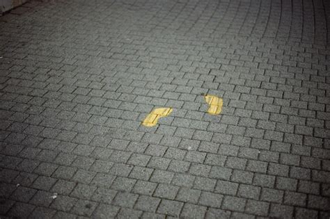 Premium Photo High Angle View Of Yellow Arrow Symbol On Footpath