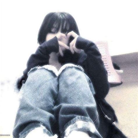 A Person Sitting On The Floor With Their Legs Crossed And Hands In