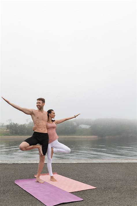 Embracing Couple In Beautiful Asana On Lake Shore By Stocksy