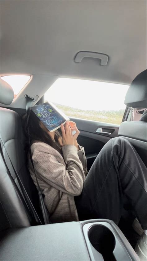 A Woman Sitting In The Back Seat Of A Car While Talking On Her Cell Phone