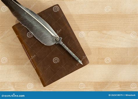 Top View Of A Feather Quill Pen With An Old Handmade Leather Notebook