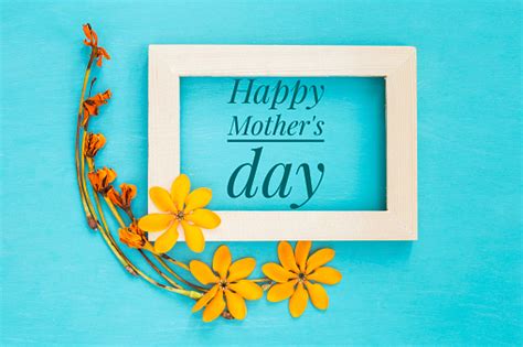 Happy Mothers Day Message In Wooden Frame With Yellow Flower On Blue