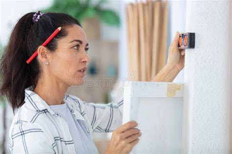Mature Woman Using Spirit Level In Kitchen Stock Image Image Of