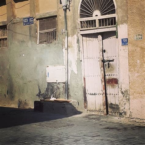 An Old Building With Two Doors And A Street Light