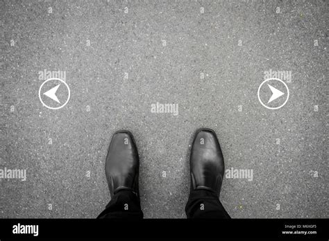 Black Shoes Standing On The Asphalt Concrete Floor And Two Directions