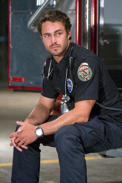 a man in uniform sitting on a bench next to a fire truck with his hand ...