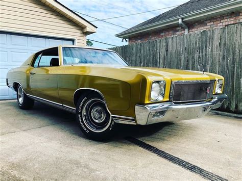 An Old Car Is Parked In Front Of A House With A Wooden Fence Behind It