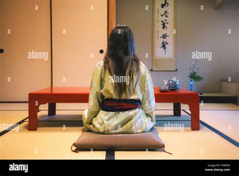 Japan, Uji, back view of woman wearing yukata drinking tea in a ...