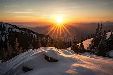 Sunrise Over Snowy Mountain Range With The Sun Peeking Over The