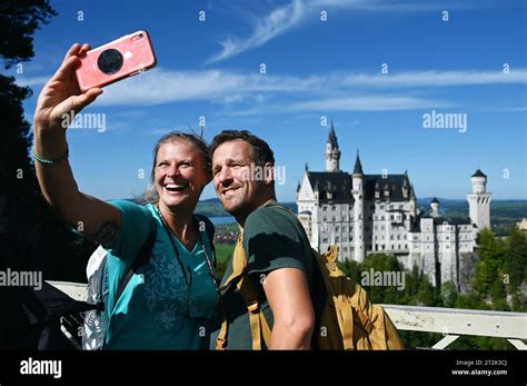 Tourists Take A Selfie With Neuschwanstein Castle In The Bavarian