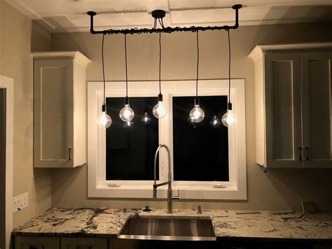 the lights are hanging over the kitchen sink