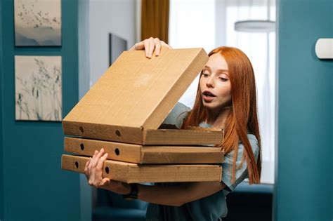 Retrato De Una Joven Sorprendida Y Emocionada Que Abre Una Caja De