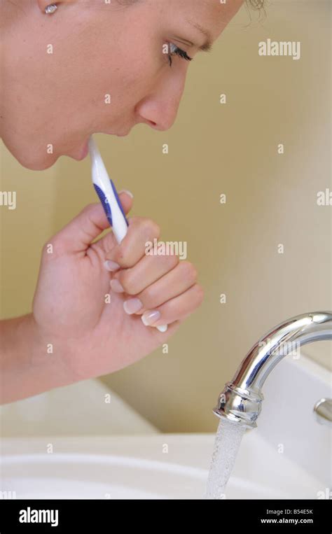 Woman Brushing Teeth With Water Running Stock Photo Alamy