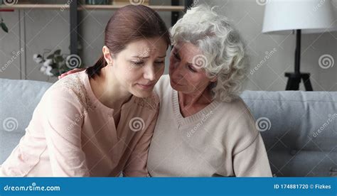 Empathic Senior Mother Comforting Sad Crying Young Adult Daughter Stock