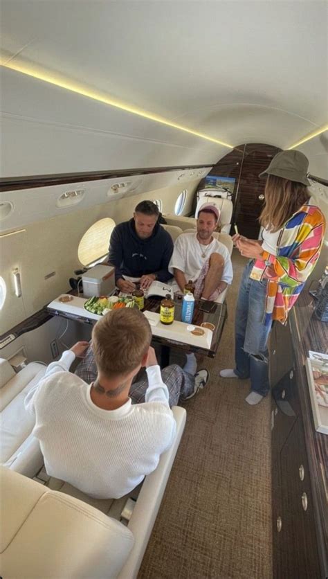 Several People Are Sitting At Tables In An Airplane