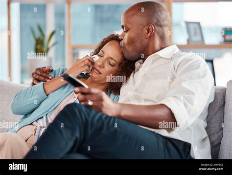 Couple Watching Tv And Kiss While Crying On Sofa Hug In Home Living