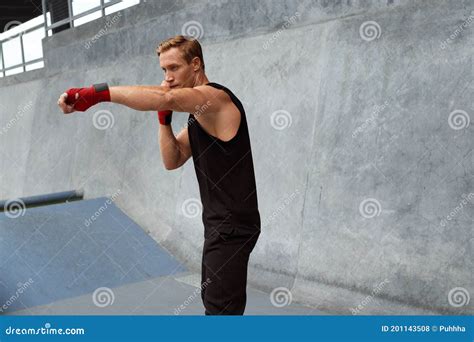 Young Man Stands In Boxing Pose And Doing Punching Workout Handsome