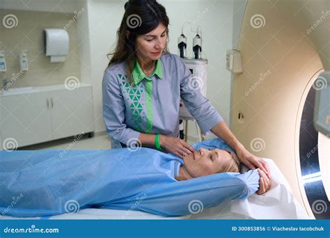 Qualified Radiographer Is Preparing Woman For Computed Tomography Stock