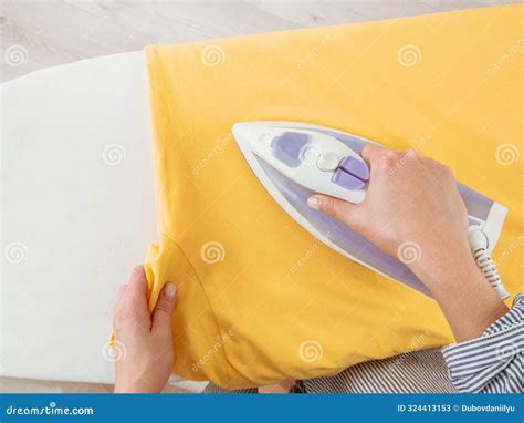 Girl Ironing Clothes With An Iron On An Ironing Board Selective Focus