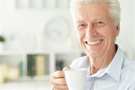 Premium Photo Portrait Of Smiling Senior Man Drinking Coffee At Home