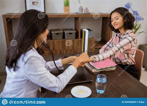 Female Patient Checked Heart Rate By Doctor With Stethoscope Stock