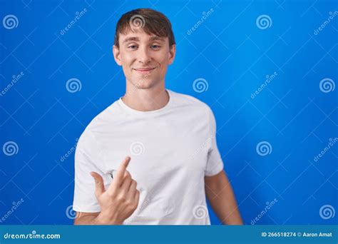 Caucasian Blond Man Standing Over Blue Background Beckoning Come Here